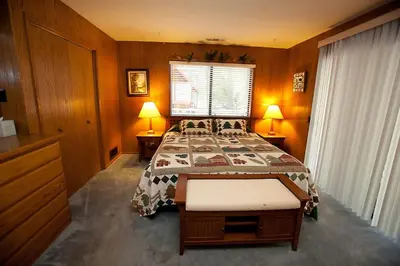 a bedroom with a bed and two lamps and a window at 48R The Tree House II in Wawona