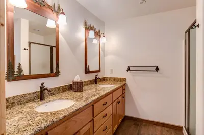 a bathroom with two sinks and two mirrors at 36 Larkspur Lair in Wawona