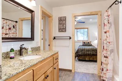 a bathroom with a sink and a mirror and a bedroom at 36 Larkspur Lair in Wawona