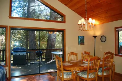 a dining room with a table and chairs and a balcony at 5N Edmond's Place in Wawona