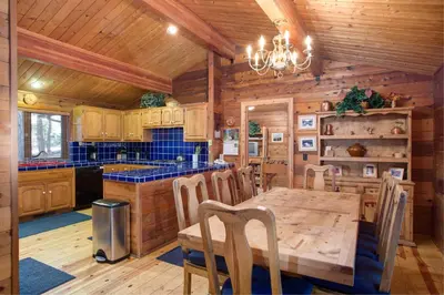 a dining room with a table and a kitchen at 41A Cedar Chalet in Wawona