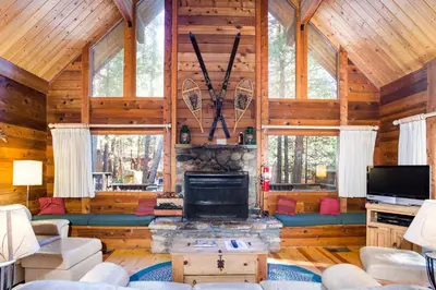 a living room with a fireplace in a log cabin at 41A Cedar Chalet in Wawona
