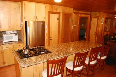 a kitchen with a counter with a stove and chairs at 92 Harmony Villa in Wawona
