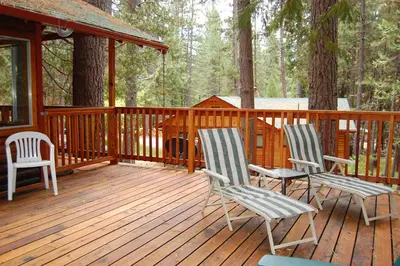 two chairs and a table on a wooden deck at 92 Harmony Villa in Wawona