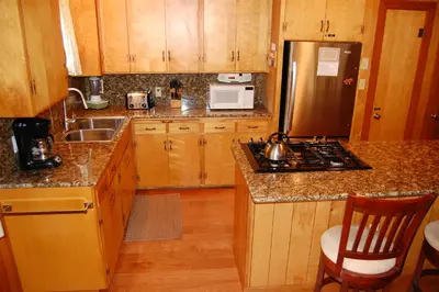 a kitchen with wooden cabinets and a stainless steel refrigerator at 92 Harmony Villa in Wawona