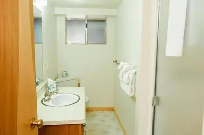 a white bathroom with a sink and a mirror at 19B Yosemite Retreat in the Meadows in Wawona