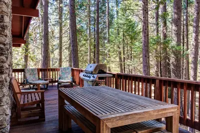 a deck with a grill and a table and chairs at 23B Robins Nest in North Wawona