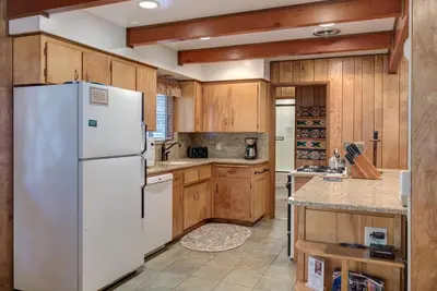 a kitchen with a white refrigerator and wooden cabinets at 23B Robins Nest in North Wawona
