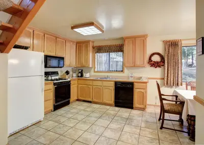 a kitchen with wooden cabinets and a white refrigerator at 12 Cabin Twelve in Wawona