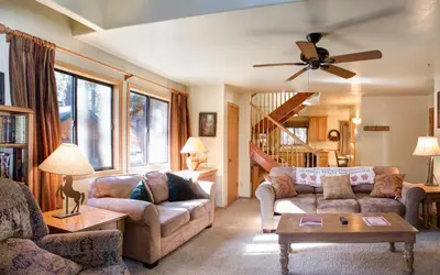 a living room with two couches and a ceiling fan at 12 Cabin Twelve in Wawona