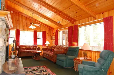 a living room with couches and chairs and windows at 93R Deer Lodge in North Wawona
