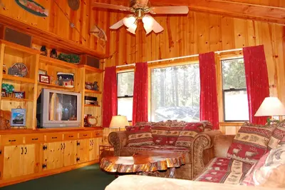 a living room with a couch and a table and a tv at 93R Deer Lodge in North Wawona