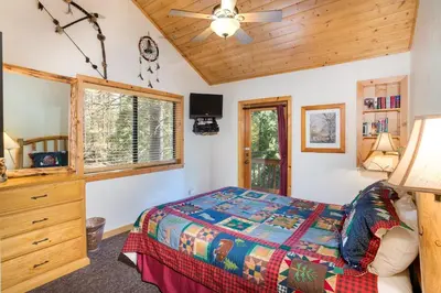 a bedroom with a bed and a dresser and a window at 21 River Refuge in North Wawona
