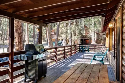 a screened in porch with a grill and chairs on it at 51 Mia Mora in Wawona