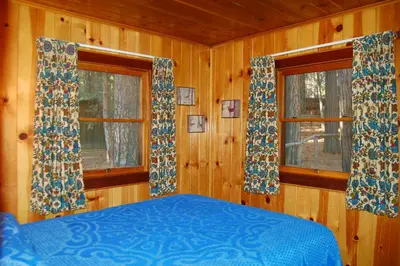 a bedroom with two windows and a blue bed at 11 Shangri la-de-da in Wawona