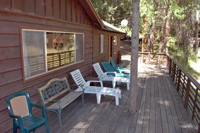 a porch with chairs and a bench on a cabin at 11 Shangri la-de-da in Wawona