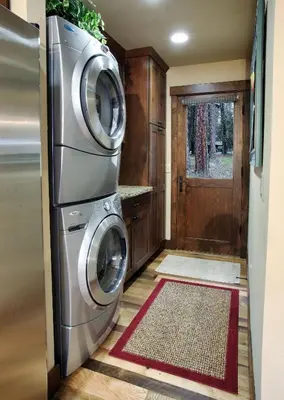 a laundry room with a washer and dryer next to a door at 9 Boot's Haven in North Wawona