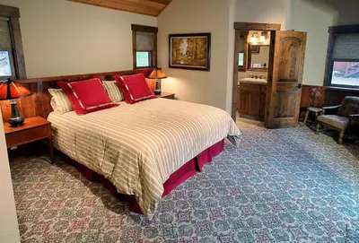 a bedroom with a bed with red pillows and a desk at 9 Boot's Haven in North Wawona