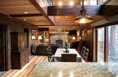 a living room with a table and a fireplace at 9 Boot's Haven in North Wawona