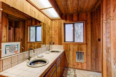a bathroom with two sinks and wooden walls at 17B Tylers Timber Lodge in Wawona