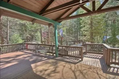 a large deck with benches on a wooden porch at 95R The Little Creek Cabin in Wawona