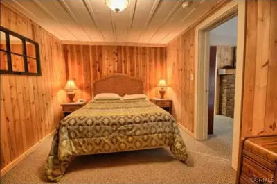 a bedroom with wooden walls and a bed in a room at 95R The Little Creek Cabin in Wawona