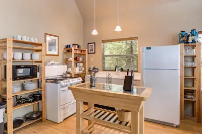 a kitchen with a white refrigerator and a table at 7S Wawona Chalet in Wawona
