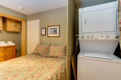 a bedroom with a bed and a washer and dryer at 7S Wawona Chalet in Wawona