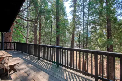 a deck with a table and chairs and trees at 18B Hiltbrand Hangout in Wawona