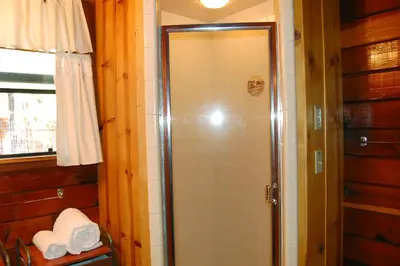 a shower with a glass door in a bathroom at 35 Cubbys Den in Wawona