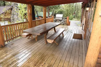 a wooden porch with a wooden bench on a deck at 79 Half Dome in Wawona
