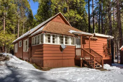 a small cabin in the snow in the woods at 80 Chattertons Cottage in North Wawona