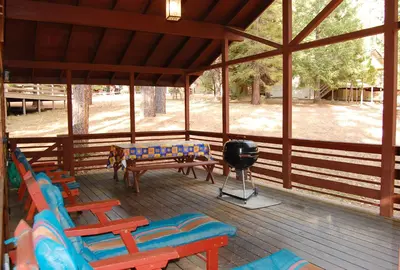 a screened in porch with chairs and a grill at 84 Hastings Hideaway in Wawona