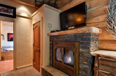 a living room with a fireplace with a flat screen tv at 67 El Capitan in North Wawona