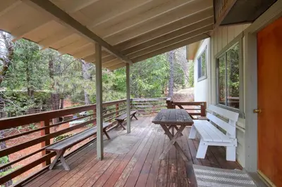 a porch with benches and a table on it at 25A Villarreal Retreat in Wawona