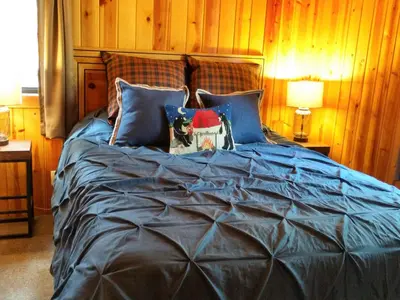 a large bed with blue sheets and pillows at 57 The Williams Cabin in Wawona