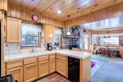 a kitchen with wooden cabinets and a dining room at 7 Cedar Lodge in Wawona