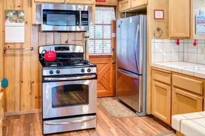 a kitchen with a stove and a refrigerator at 7 Cedar Lodge in Wawona