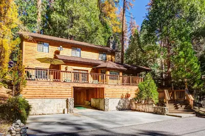 a large wooden house with a large deck at 7 Cedar Lodge in Wawona