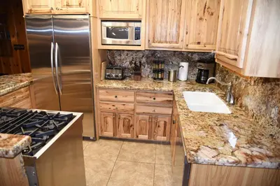 a kitchen with wooden cabinets and a stainless steel refrigerator at 52 Tuolumne Meadow in Wawona