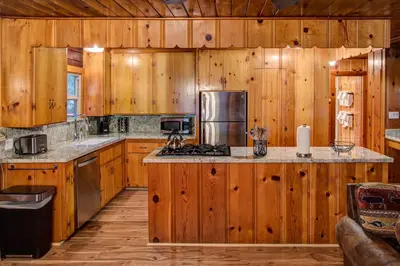 a kitchen with wooden cabinets and a stove top oven at 74 Our Yosemite Getaway in Wawona