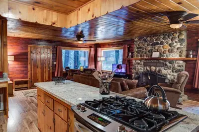 a kitchen with a stove and a living room at 74 Our Yosemite Getaway in Wawona