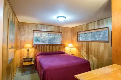 a bedroom with a purple bed and two lamps at 64 River Lodge in North Wawona