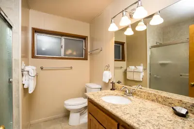 a bathroom with a sink and a toilet and a mirror at 64 River Lodge in North Wawona