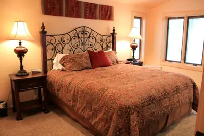 a bedroom with a bed with two lamps and two tables at 66 Grizzly Giant in Wawona