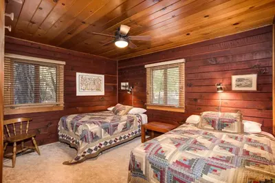 a bedroom with two beds and a ceiling fan at 53 Creekside Cabin in Wawona