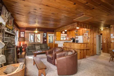 a living room with a couch and a kitchen at 53 Creekside Cabin in Wawona