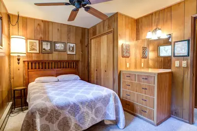 a bedroom with a bed and a wooden wall at 4B Mountain Memory in Wawona