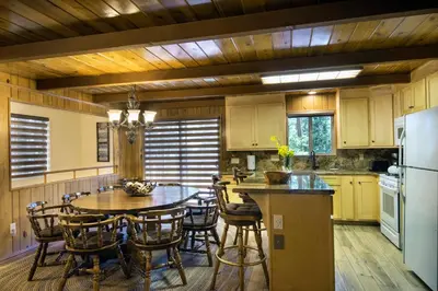 a kitchen with a table and chairs and a refrigerator at 20B We-Dunn-It in Wawona