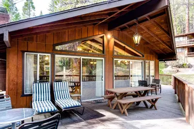 a patio with a table and chairs and windows at 12B Star Gazers in Wawona